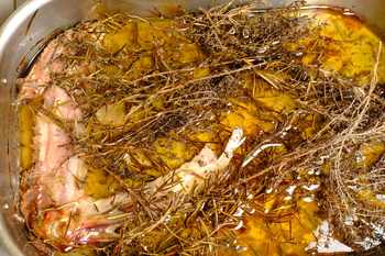 Ausgelassenes Gänsefett mit Kräutern im Bräter