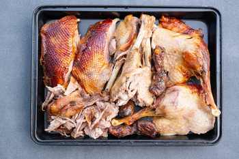 Ausgelöste, gebratene Gänsebrust und Keulen auf einem Backblech