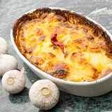 Frisch zubereitetes Kartoffelgratin in der Ofenform schräg von vorne fotografiert