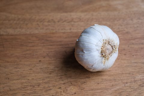 Getrocknete weiße Knoblauchknolle auf einem Holzbrett