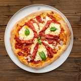 Pizza Diavola mit scharfer Salami, Mozzarella und Basilikum auf dem Teller
