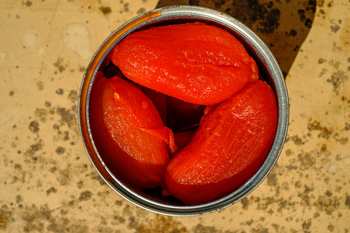 Ganze geschälte Tomaten in einer geöffneten Dose