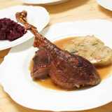 Die Weihnachtsgans, Gänsebrust und Gänsekeule knusprig zubereitet und angerichtet mit Gänsesoße, Serviettenknödel und Blaukraut